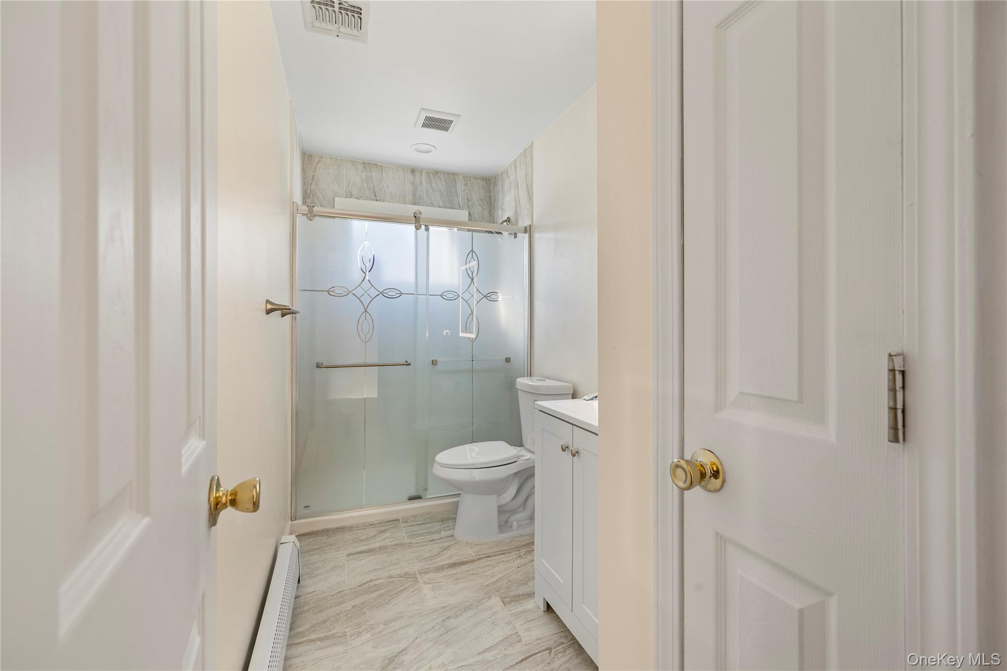 35 Pierce Road Stony Point, NY 10980 - Photo 28 of 45 Full bathroom featuring vanity, a shower stall, baseboard heating, and light marble finish flooring
