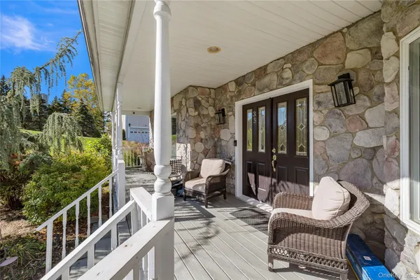 a view of a balcony with chairs and wooden floor