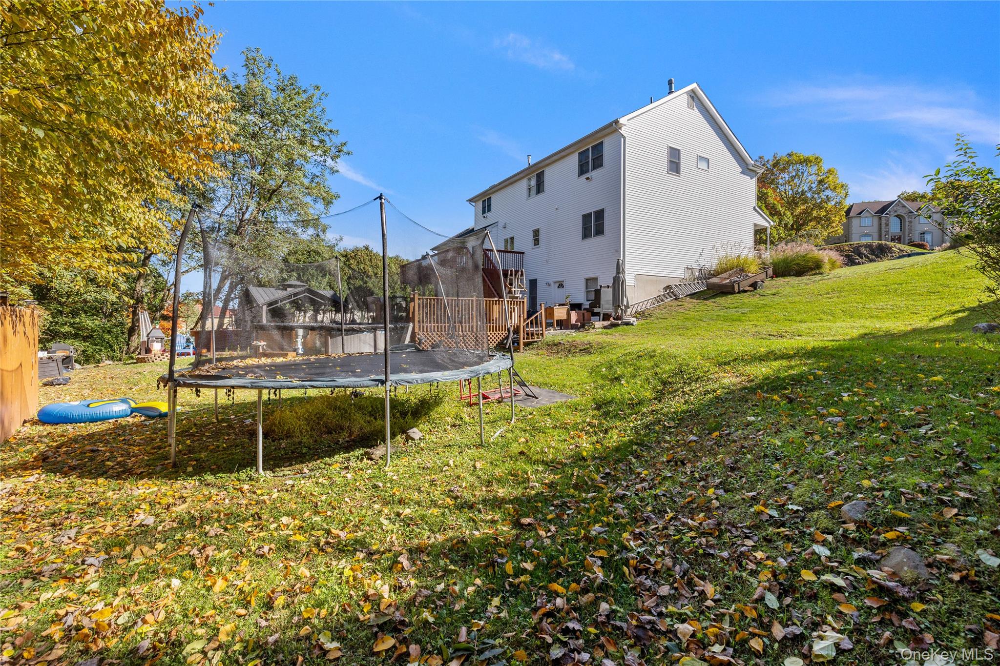 35 Pierce Road Stony Point, NY 10980 - Photo 40 of 45 Back of property with a lawn, a trampoline, a wooden deck, and stairs