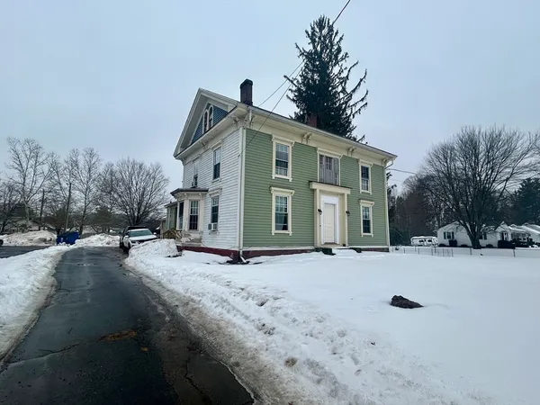 a view of a house with a yard covered in snow