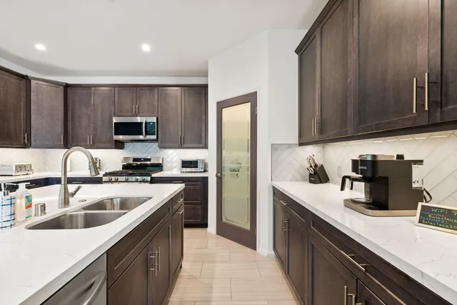 a kitchen with a sink stove top oven and refrigerator