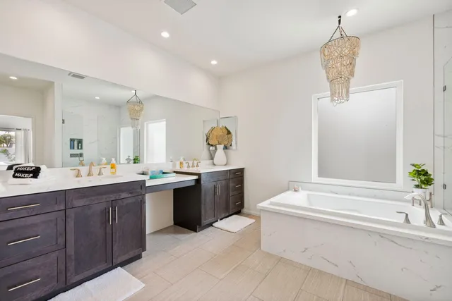 a spacious bathroom with a granite countertop sink mirror and bathtub