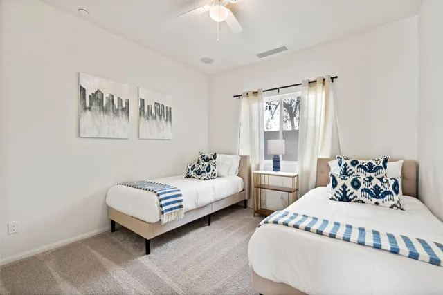 a bedroom with two beds and a large window