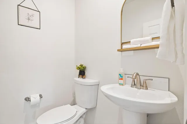 a white toilet sitting next to a bathroom sink