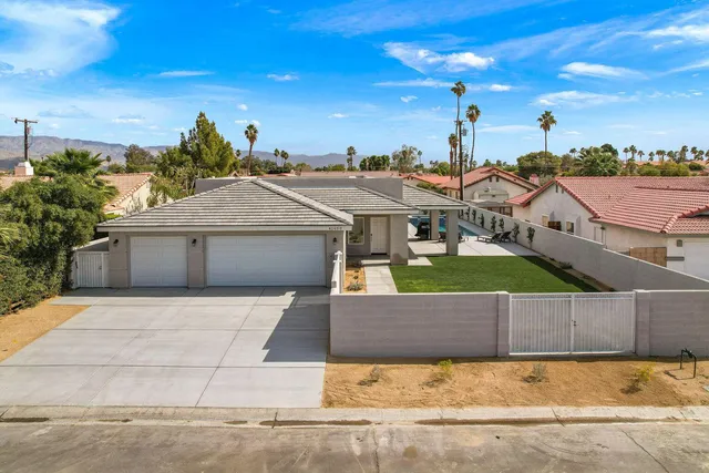 a view of a house with a yard and potted plants