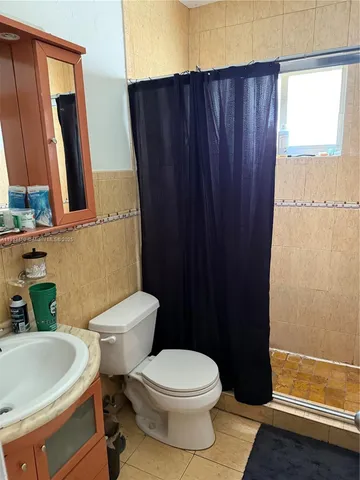 a white toilet sitting next to a bathroom sink and a tub