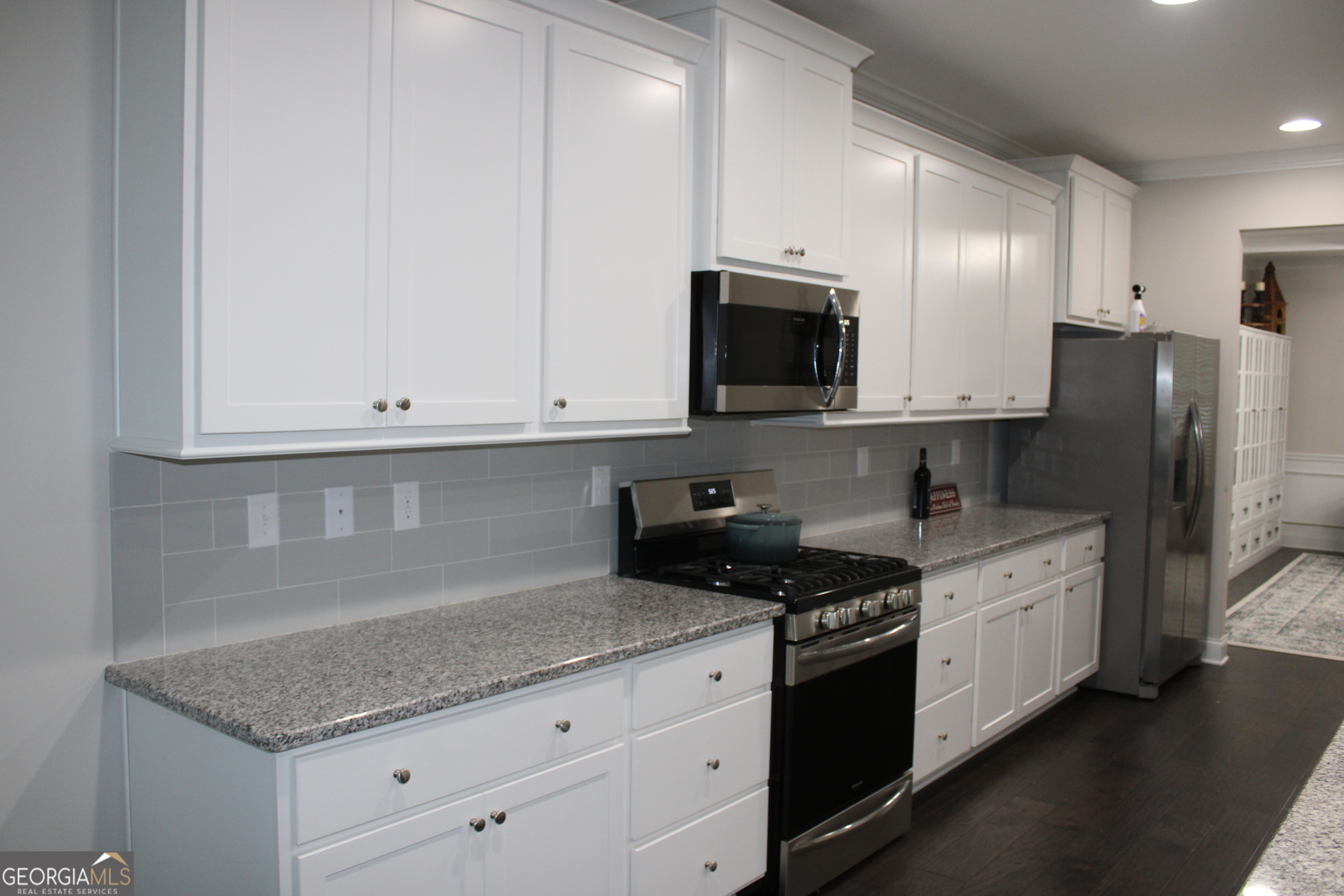 40 Owens Path Senoia, GA 30276 - Photo 5 of 21 a kitchen with granite countertop white cabinets white stainless steel appliances and granite counter tops