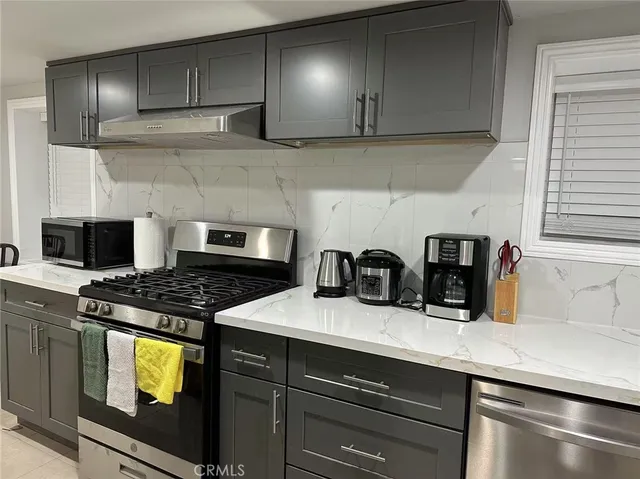 a kitchen with granite countertop a stove and a sink