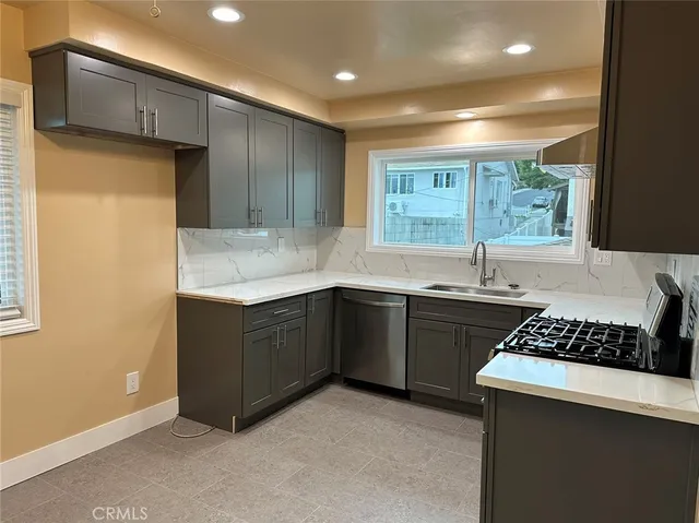 a kitchen with stainless steel appliances granite countertop a sink stove and cabinets