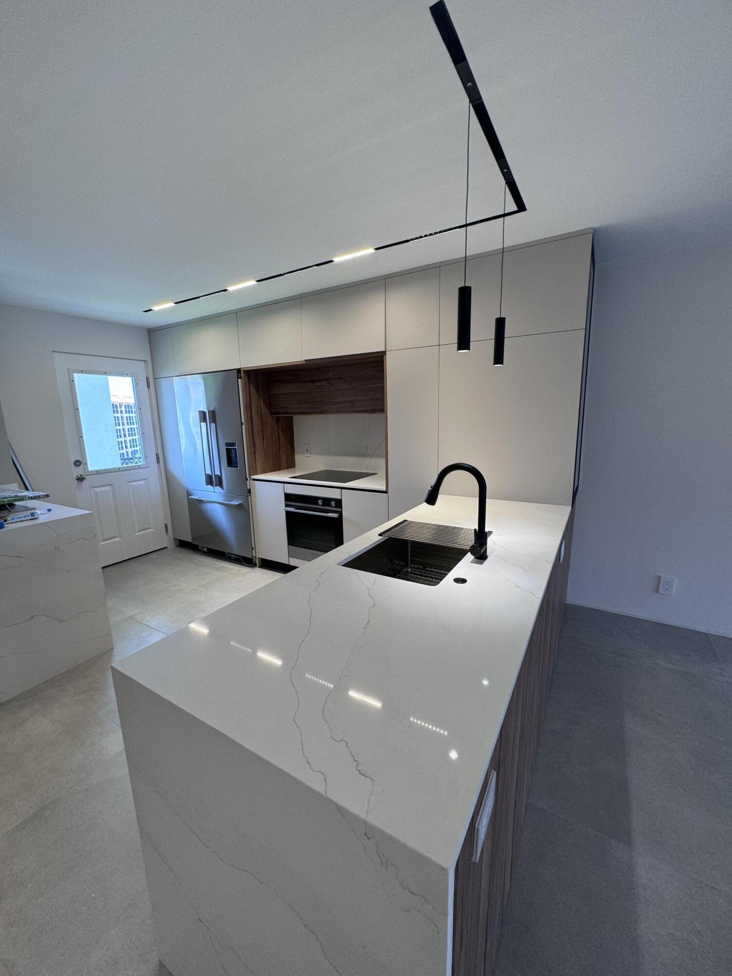 2871 North Ocean Boulevard, Unit R444 Boca Raton, FL 33431 - Photo 1 of 42 a kitchen with stainless steel appliances granite countertop a sink and a stove top oven with wooden floor