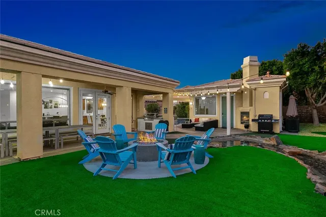 a view of a patio with table and chairs potted plants and a big yard