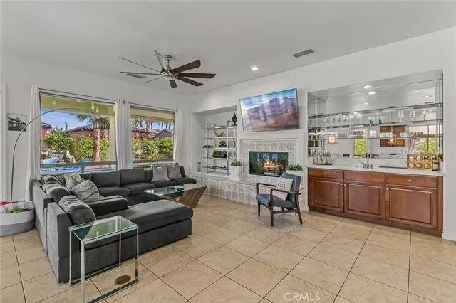 a living room with furniture kitchen view and a chandelier