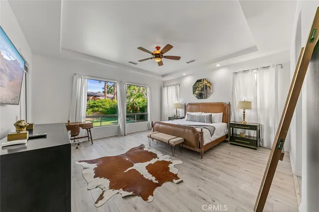 a spacious bedroom with a bed a couch and a chandelier