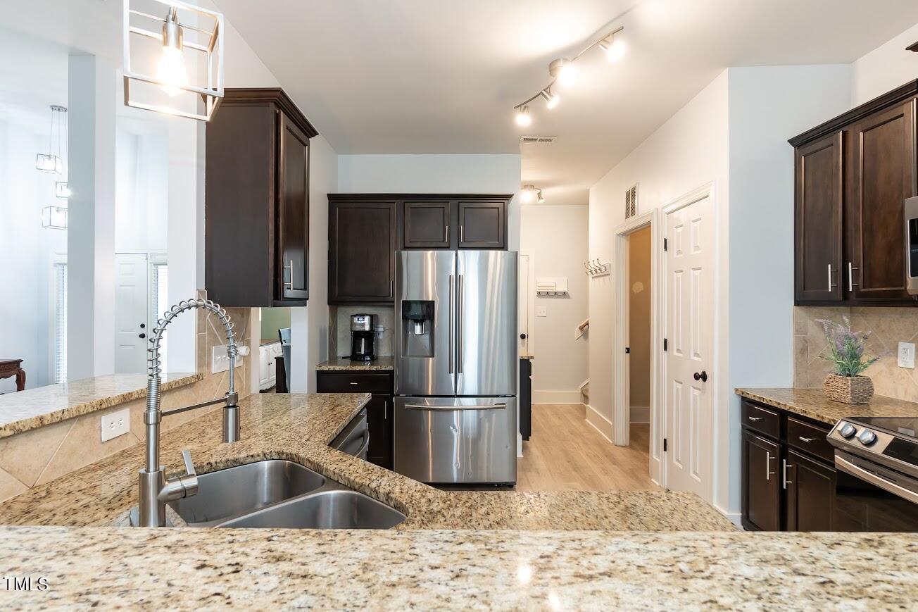 91 Colson Drive Garner, NC 27529 - Photo 18 of 46 a kitchen with stainless steel appliances kitchen island granite countertop a refrigerator stove and sink