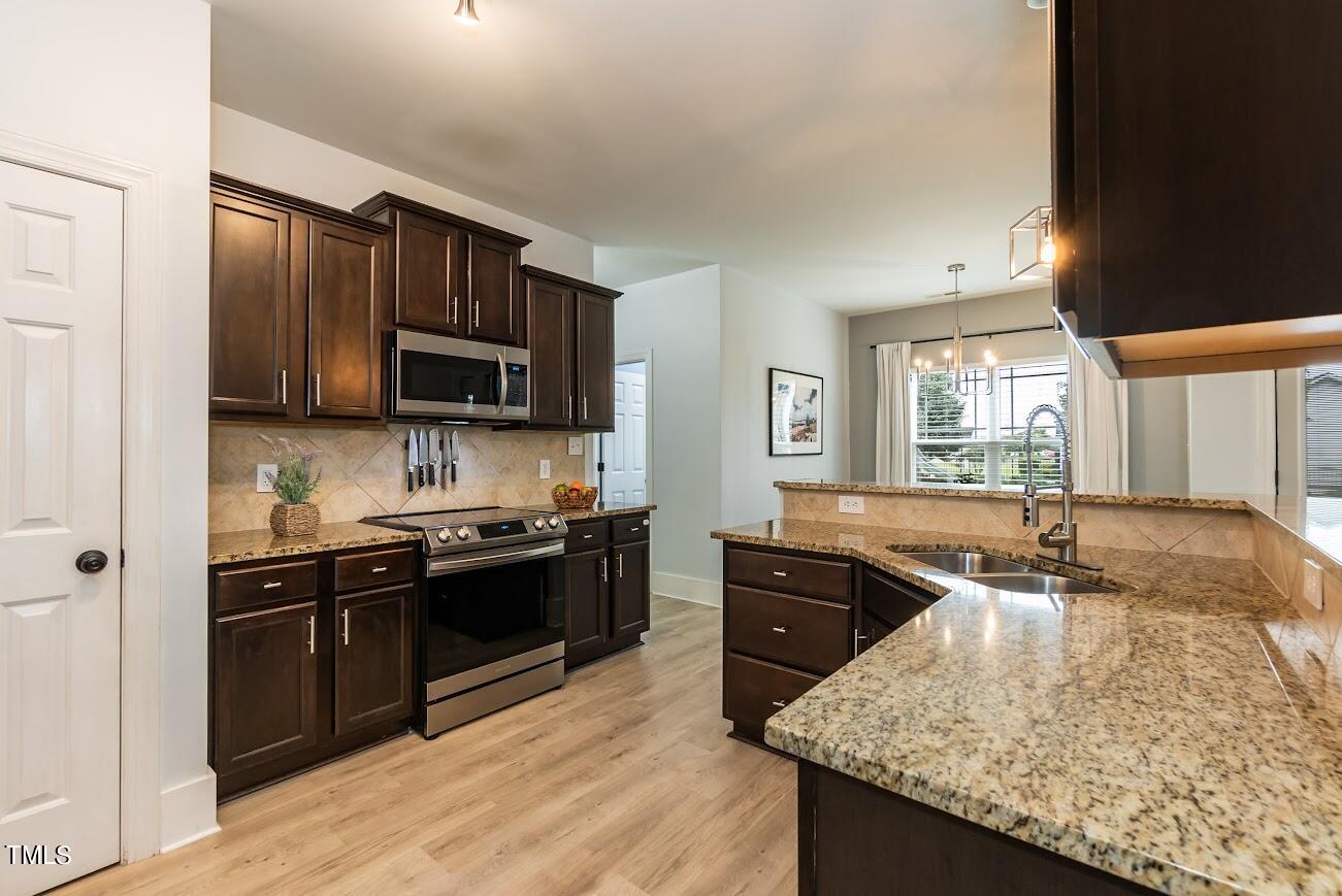 91 Colson Drive Garner, NC 27529 - Photo 20 of 46 a kitchen with stainless steel appliances granite countertop a sink stove and refrigerator
