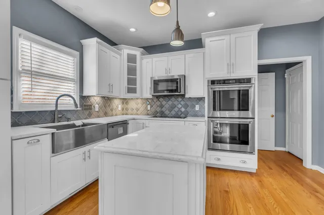 a kitchen with stainless steel appliances a stove a sink and a microwave