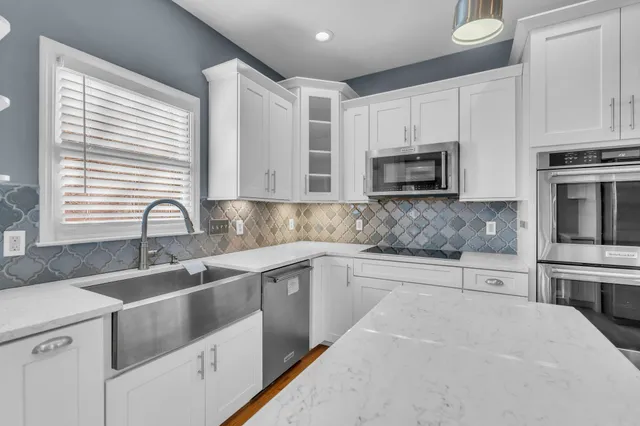 a kitchen with stainless steel appliances granite countertop a sink a stove a microwave and cabinets