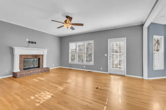 a view of an empty room with a fireplace and a window