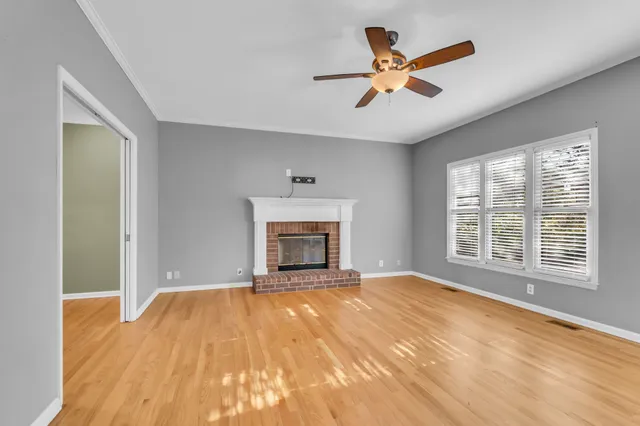 a view of an empty room with a fireplace and a window