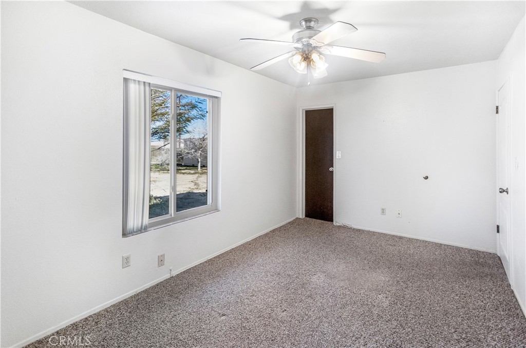 63542 Jadeite Street Joshua Tree, CA 92252 - Photo 23 of 37 an empty room with windows and fan