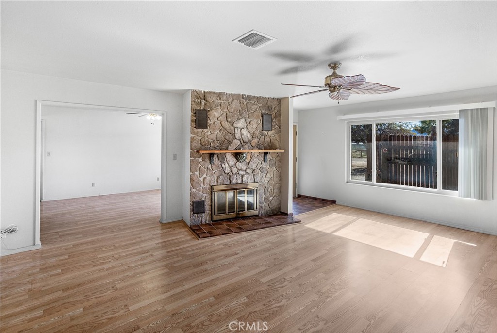 63542 Jadeite Street Joshua Tree, CA 92252 - Photo 8 of 37 a view of an empty room with a window and wooden floor