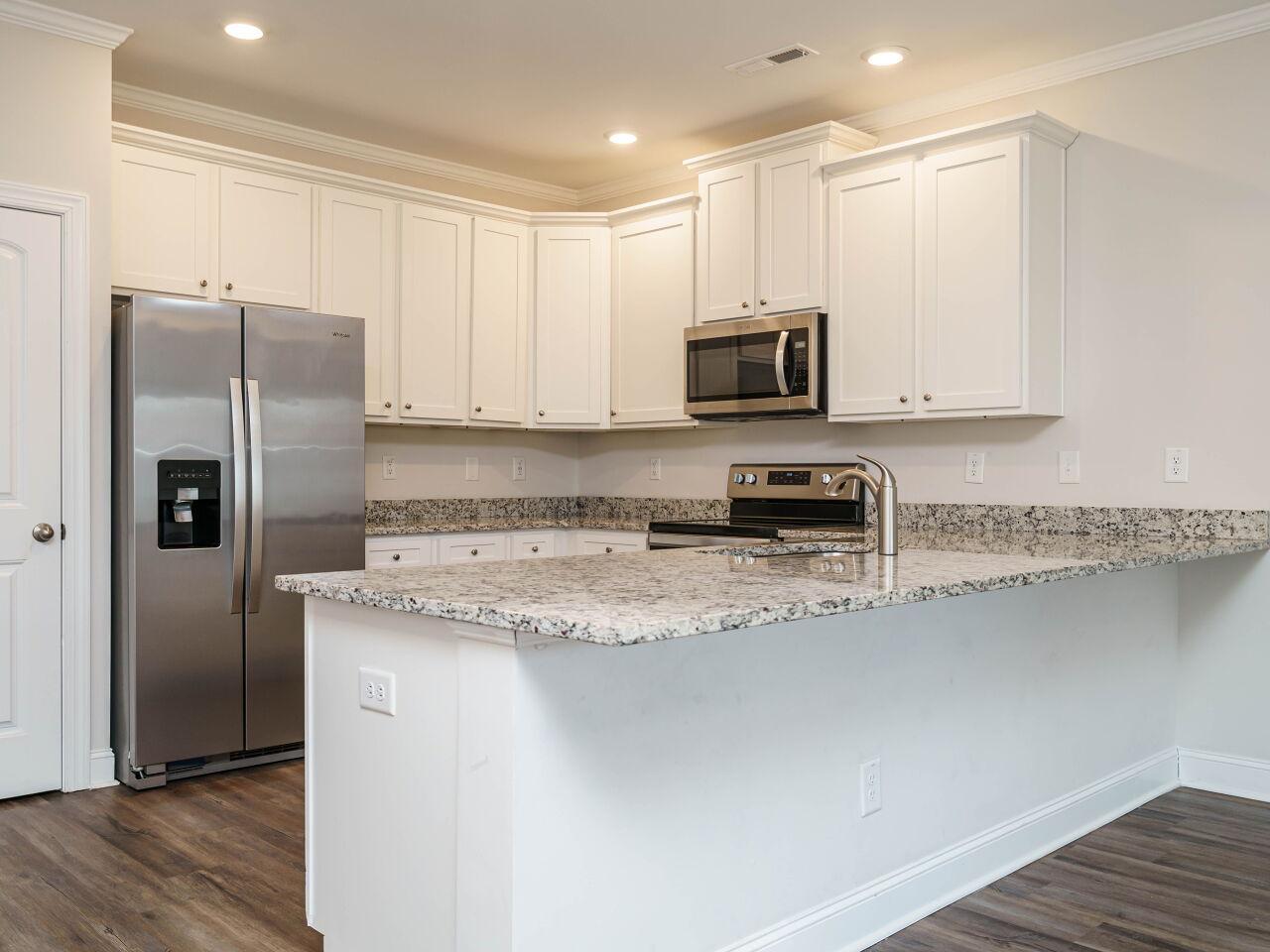 6914 Eddy Point Lane Raleigh, NC 27616 - Photo 12 of 33 a kitchen with stainless steel appliances granite countertop a refrigerator a stove a sink and white cabinets with wooden floor