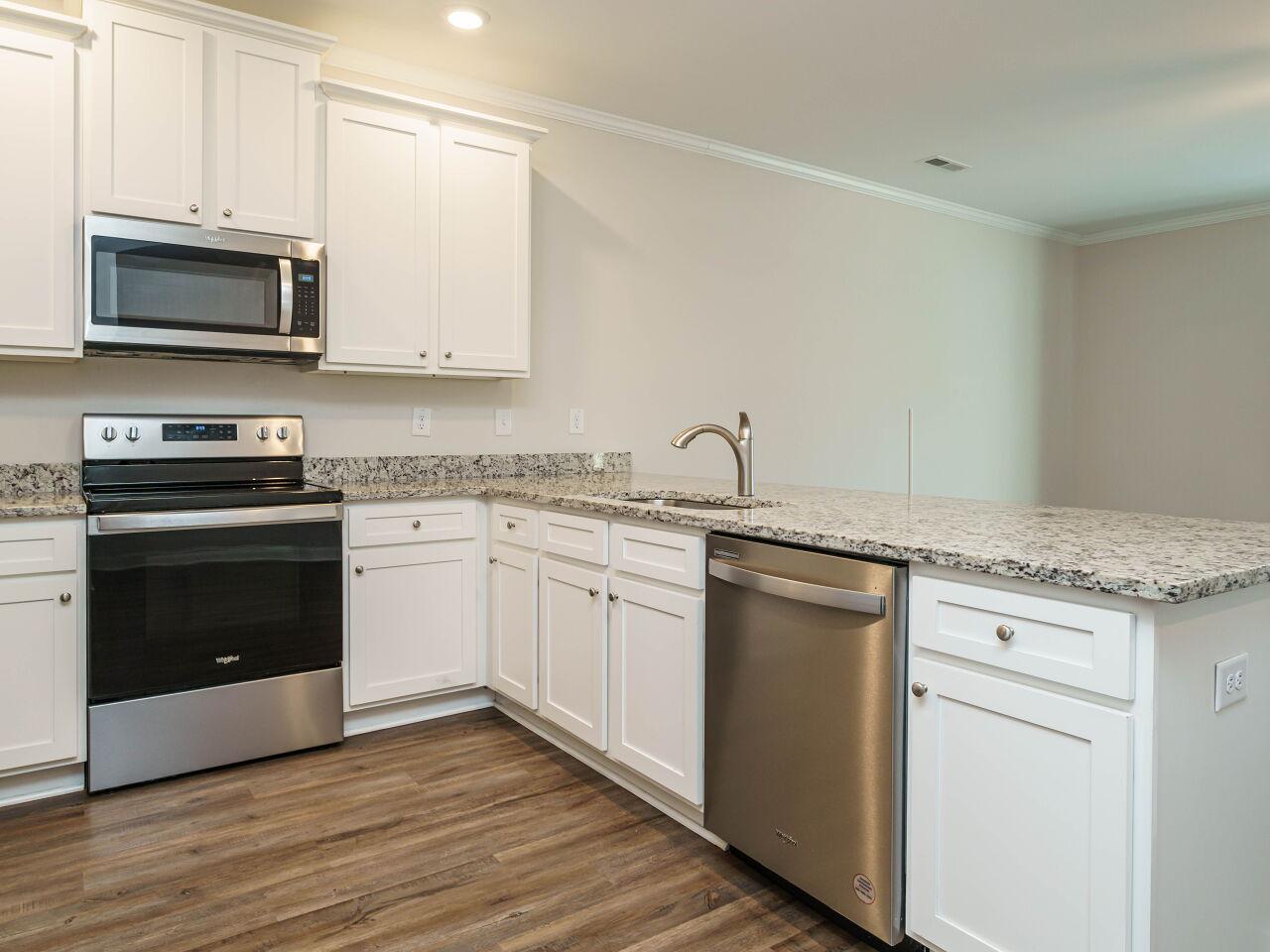 6914 Eddy Point Lane Raleigh, NC 27616 - Photo 14 of 33 a kitchen with granite countertop white cabinets and white appliances