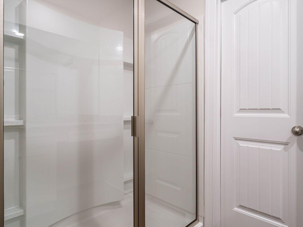 6914 Eddy Point Lane Raleigh, NC 27616 - Photo 22 of 33 a bathroom with a glass shower door