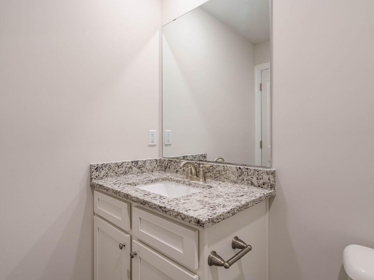 6914 Eddy Point Lane Raleigh, NC 27616 - Photo 25 of 33 a bathroom with a granite countertop sink and a mirror