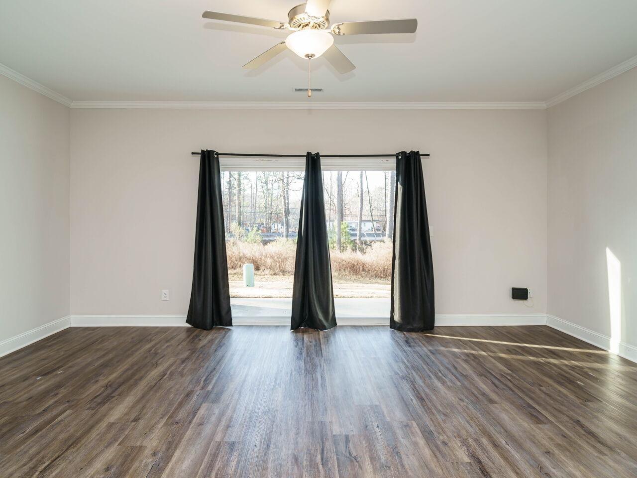 6914 Eddy Point Lane Raleigh, NC 27616 - Photo 8 of 33 a view of an empty room with wooden floor and a window