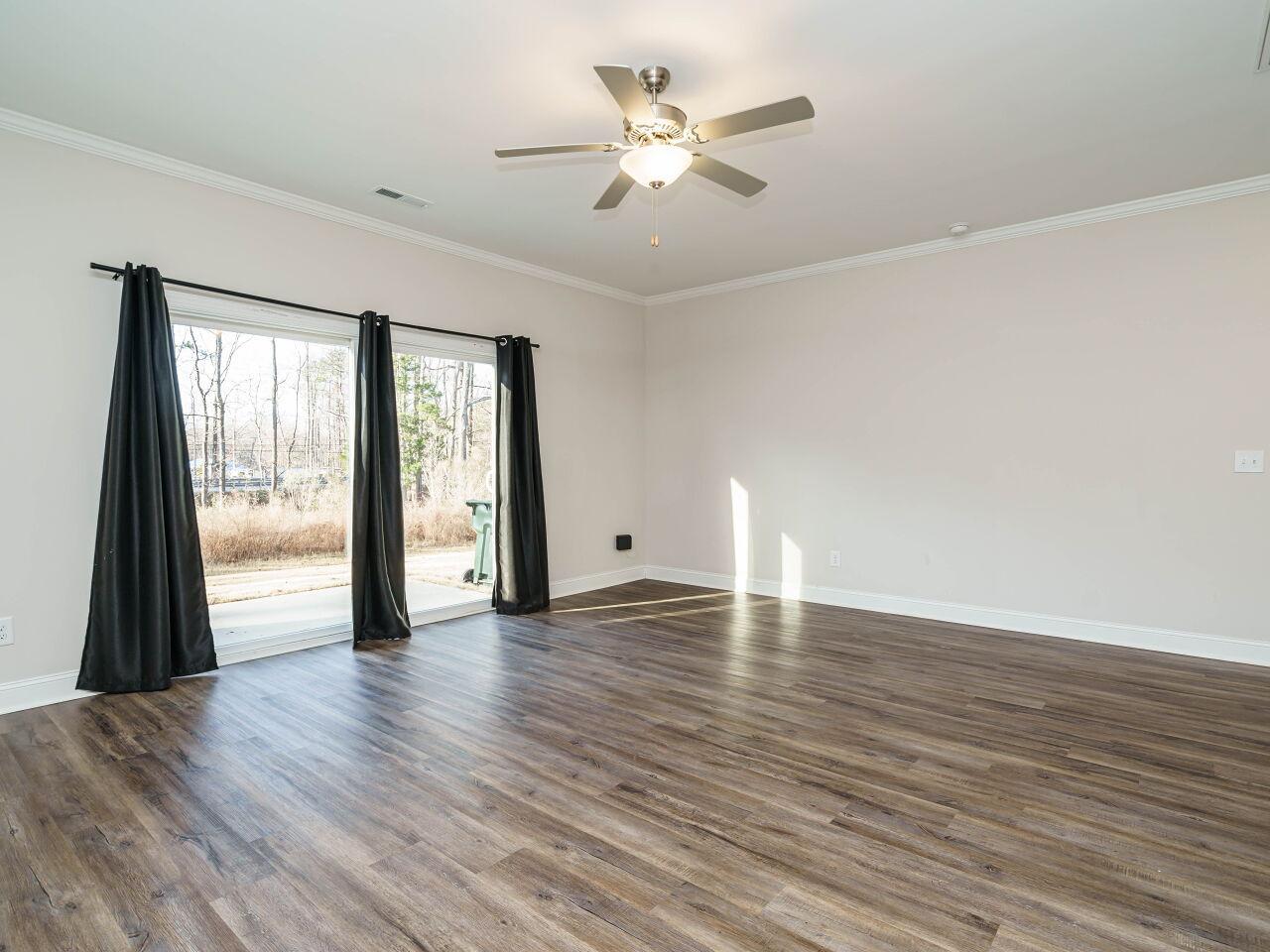 6914 Eddy Point Lane Raleigh, NC 27616 - Photo 10 of 33 a view of an empty room with window and wooden floor