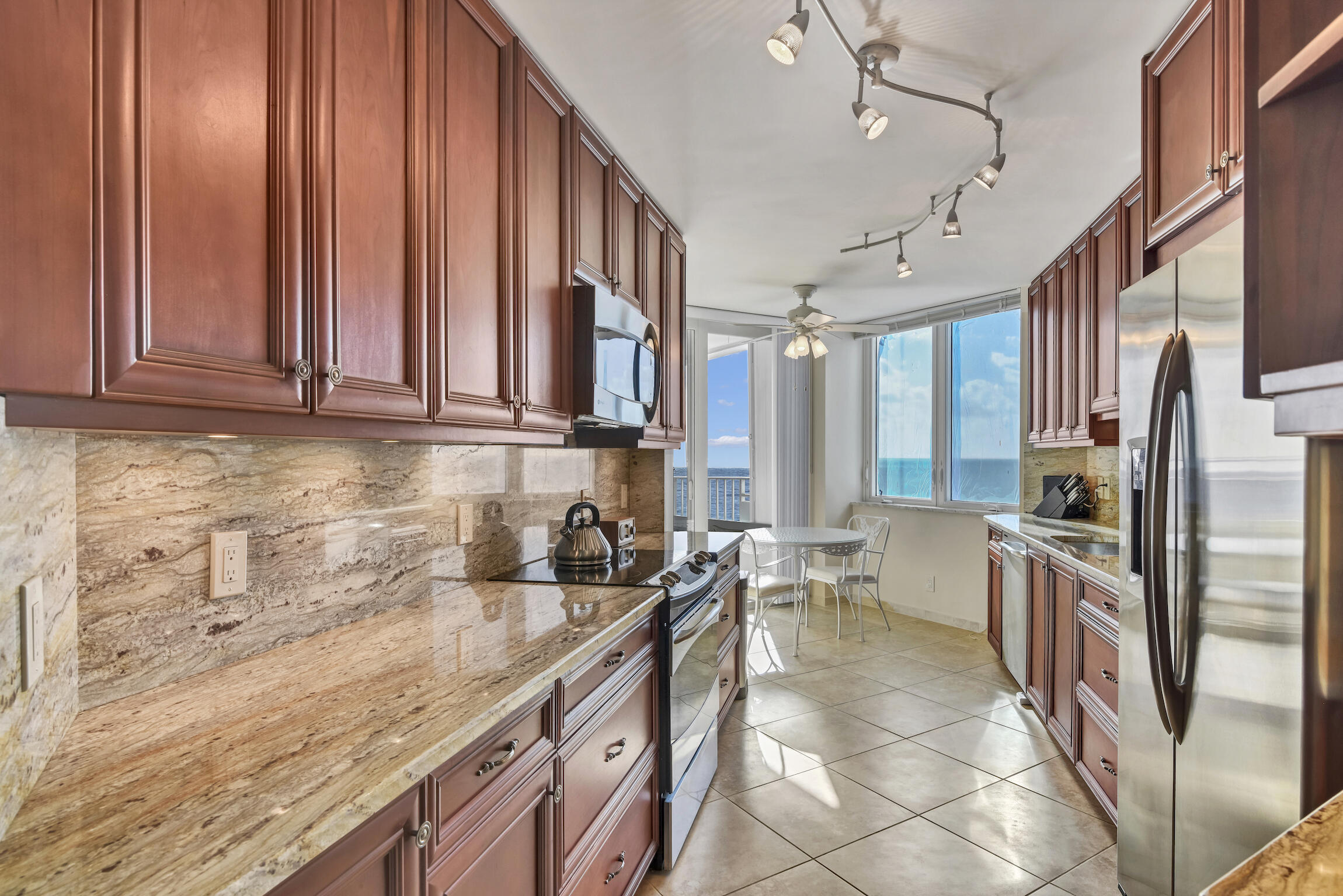 500 South Ocean Boulevard, Unit 1006 Boca Raton, FL 33432 - Photo 15 of 40 a kitchen with stainless steel appliances granite countertop a sink stove and cabinets