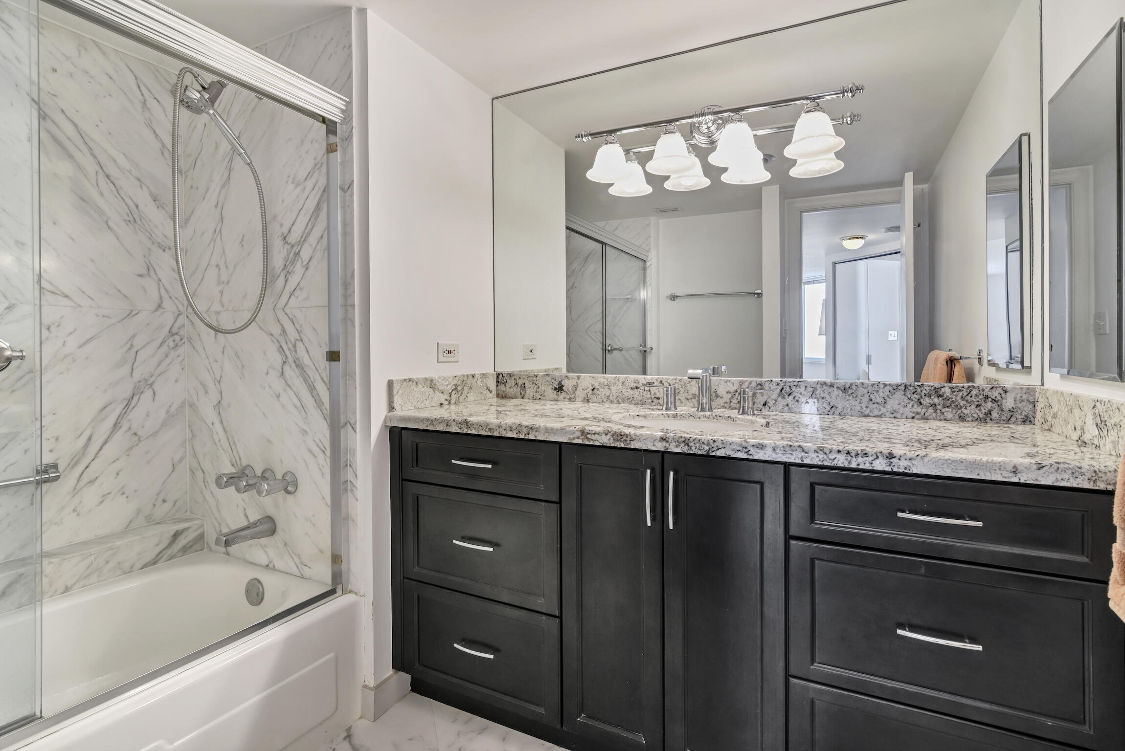 500 South Ocean Boulevard, Unit 1006 Boca Raton, FL 33432 - Photo 18 of 40 a bathroom with a granite countertop sink a large mirror and a bathtub