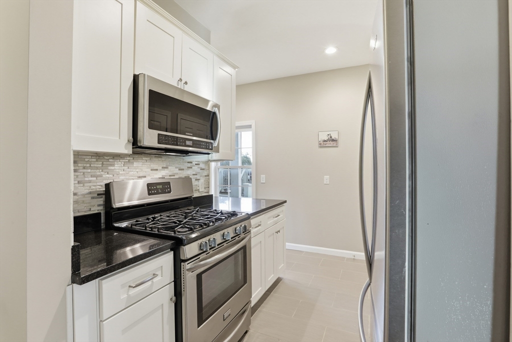9 Montgomery Avenue, Unit 1 Somerville, MA 02145 - Photo 12 of 27 a kitchen with stainless steel appliances a stove microwave and sink