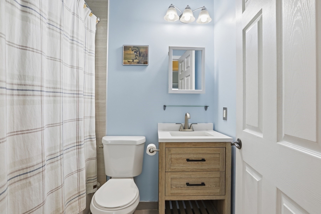 9 Montgomery Avenue, Unit 1 Somerville, MA 02145 - Photo 19 of 27 a bathroom with a toilet sink vanity and mirror