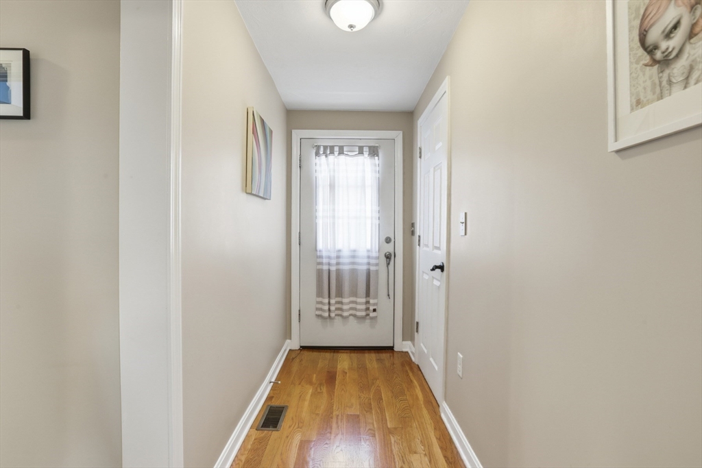9 Montgomery Avenue, Unit 1 Somerville, MA 02145 - Photo 21 of 27 a view of a hallway with wooden floor and a bathroom