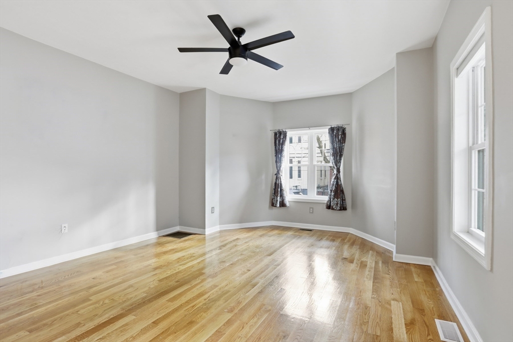 9 Montgomery Avenue, Unit 1 Somerville, MA 02145 - Photo 8 of 27 a view of empty room with wooden floor and fan