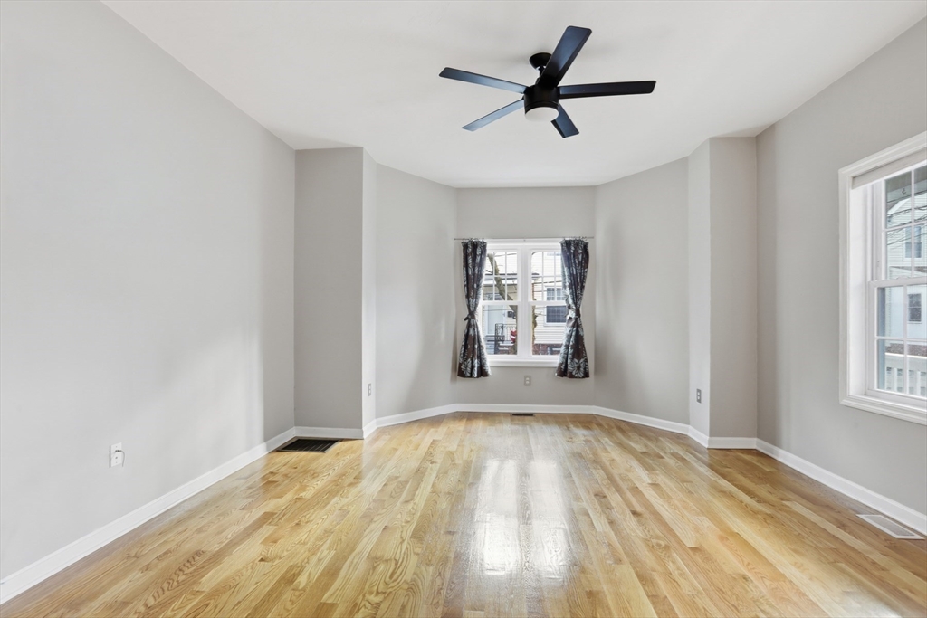 9 Montgomery Avenue, Unit 1 Somerville, MA 02145 - Photo 9 of 27 a view of empty room with wooden floor and window