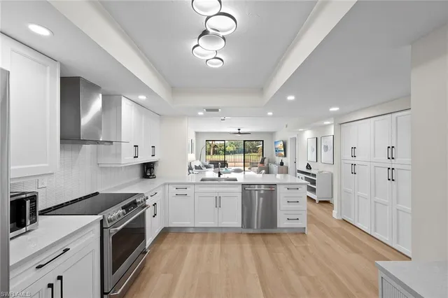 a kitchen with a sink stove cabinets and wooden floor