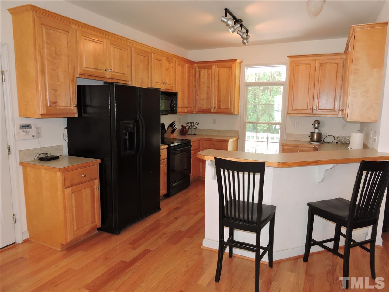 3360 Cates Mill Road Roxboro, NC 27574 - Photo 5 of 17 a kitchen with stainless steel appliances granite countertop a refrigerator a stove a sink dishwasher and a refrigerator with wooden floor