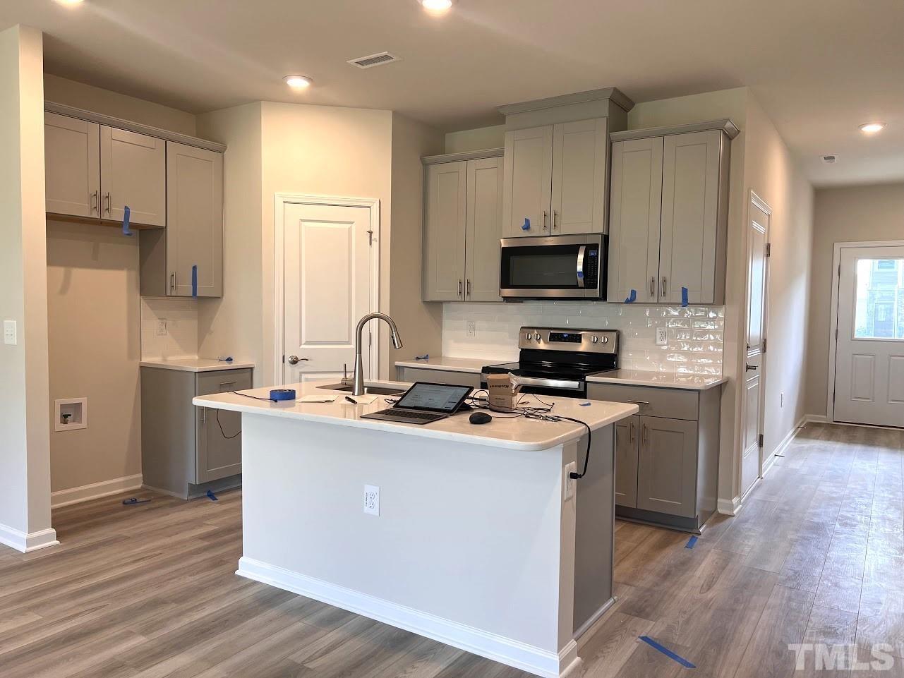 926 Field Ivy Drive Fuquay-Varina, NC 27526 - Photo 2 of 12 a kitchen with stainless steel appliances a stove a sink a refrigerator and a microwave