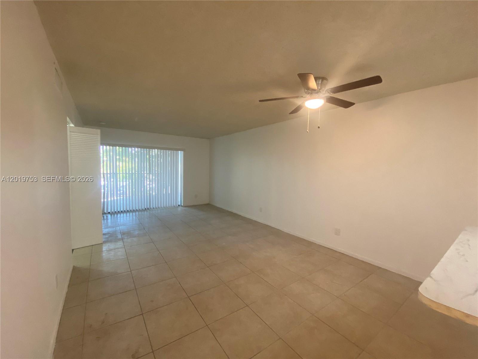 3410 Foxcroft Road, Unit 206 Miramar, FL 33025 - Photo 2 of 23 an empty room with a ceiling fan and a window
