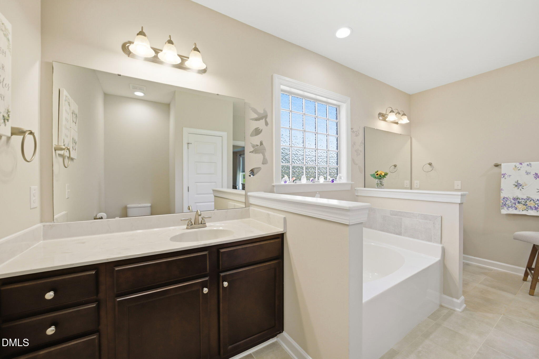 1547 Lassiter Pond Road Four Oaks, NC 27524 - Photo 22 of 45 a bathroom with a sink vanity tub and a mirror