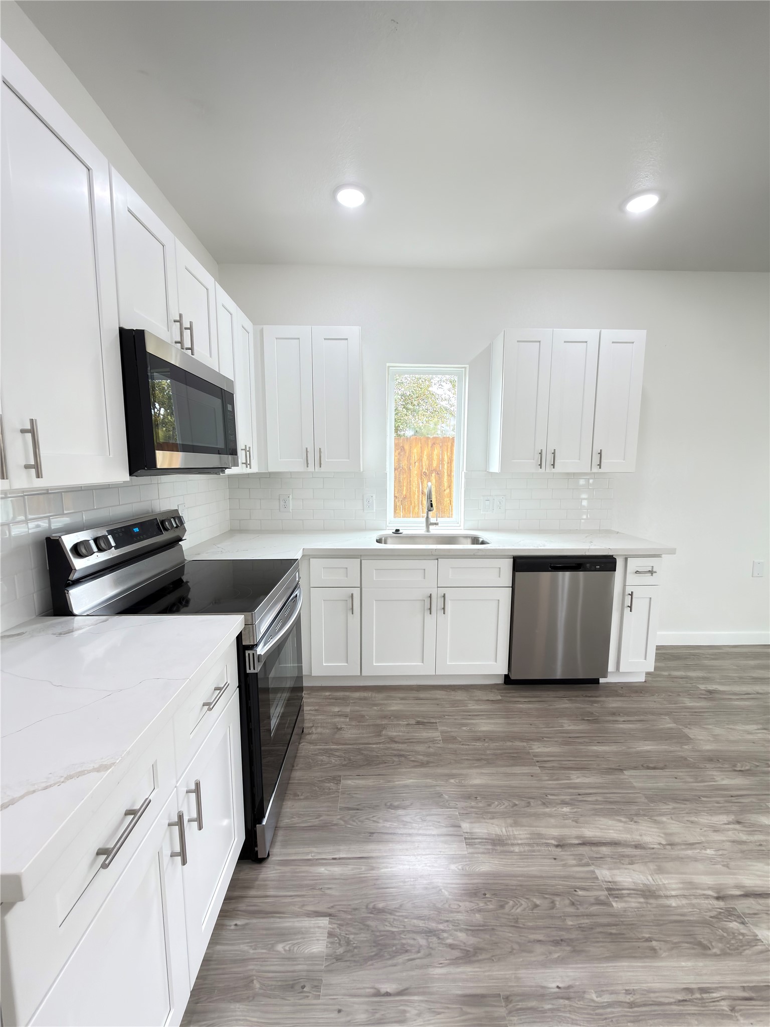 Modern open-concept kitchen seamlessly connects to the dining area, with the added convenience of a half bath on the main level.