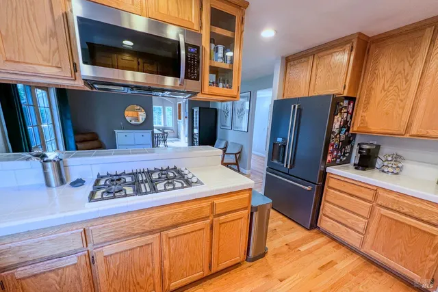 a kitchen with stainless steel appliances granite countertop a stove refrigerator and microwave