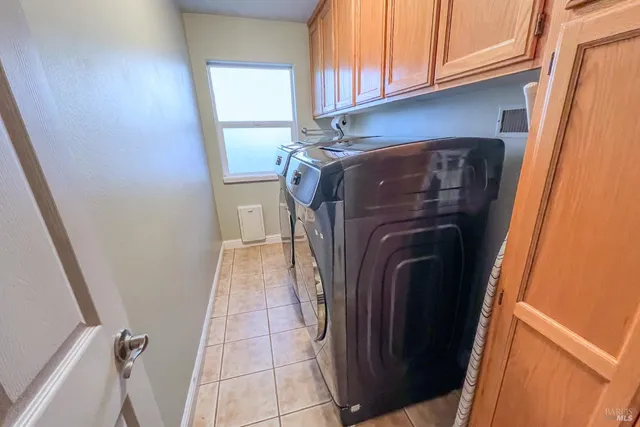 a view of a backyard with table and chairs potted plants and large tree