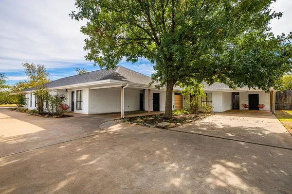 a view of a house with a yard and large tree