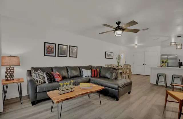 a living room with furniture ceiling fan and a window