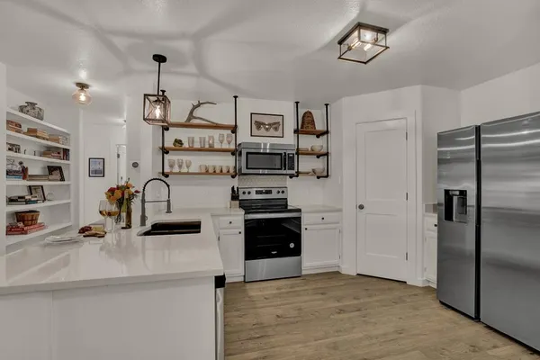 a kitchen with stainless steel appliances granite countertop a refrigerator and a sink