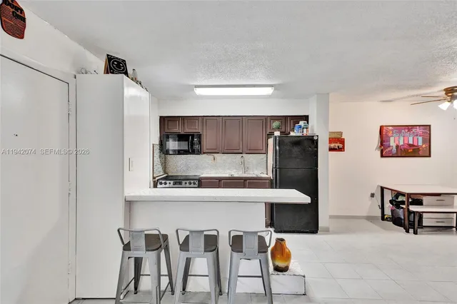 a kitchen with stainless steel appliances kitchen island granite countertop a refrigerator and microwave